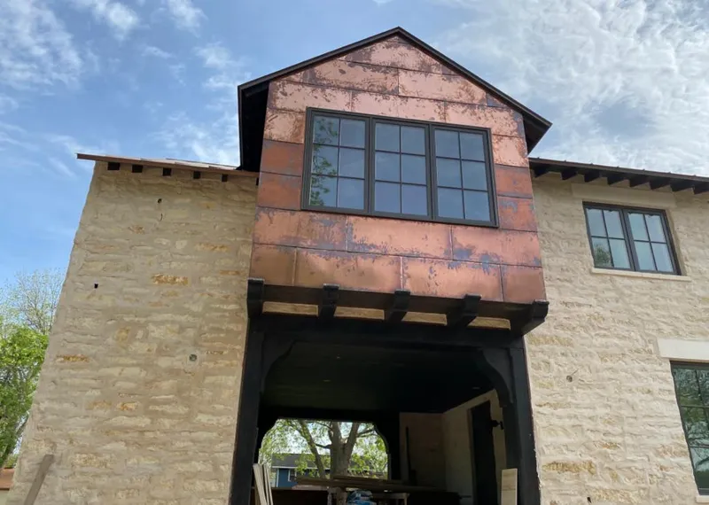 Copper metal panel facade on a stone building for Skylight Installation in Garland
